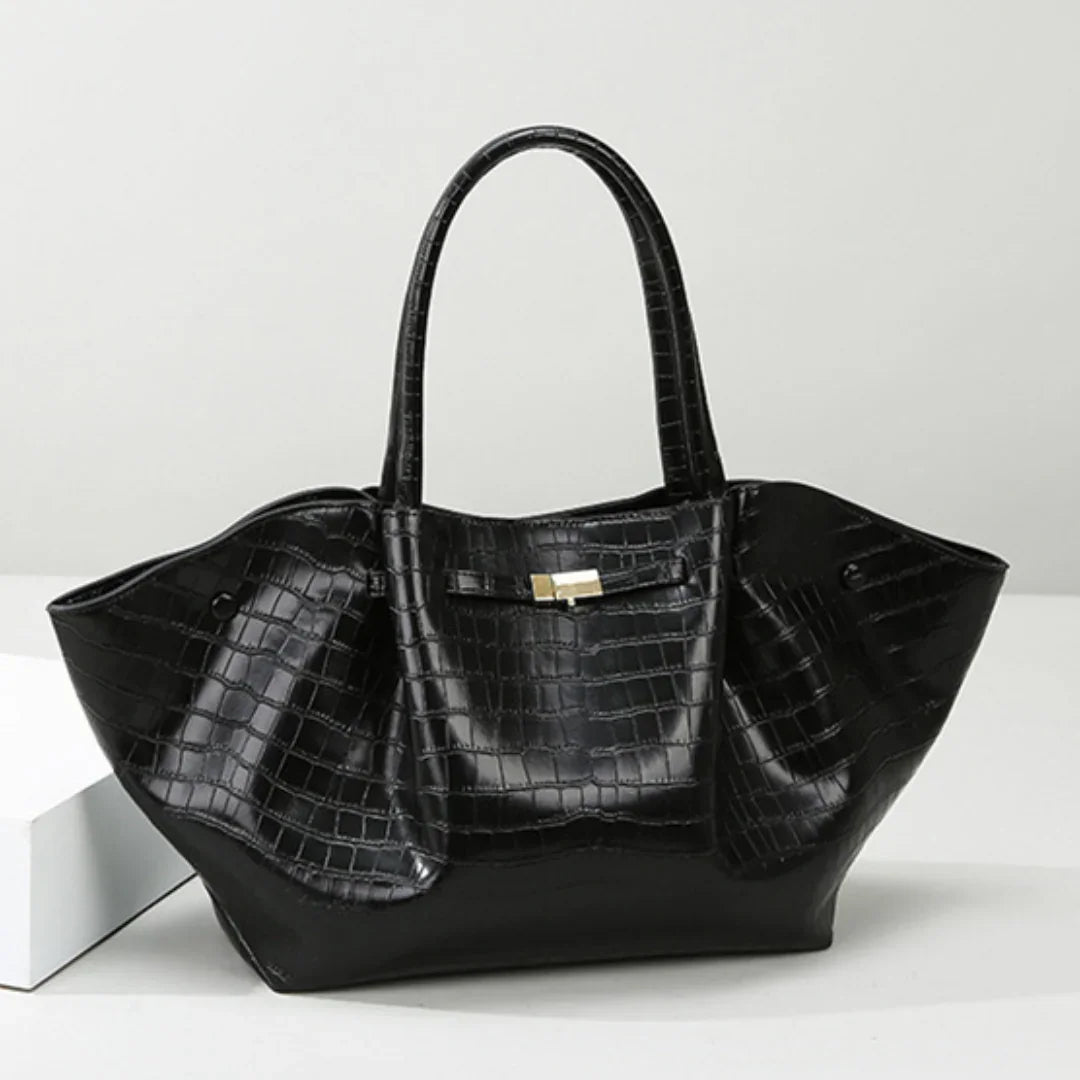 Black crocodile pattern leather tote bag with gold clasp on white background