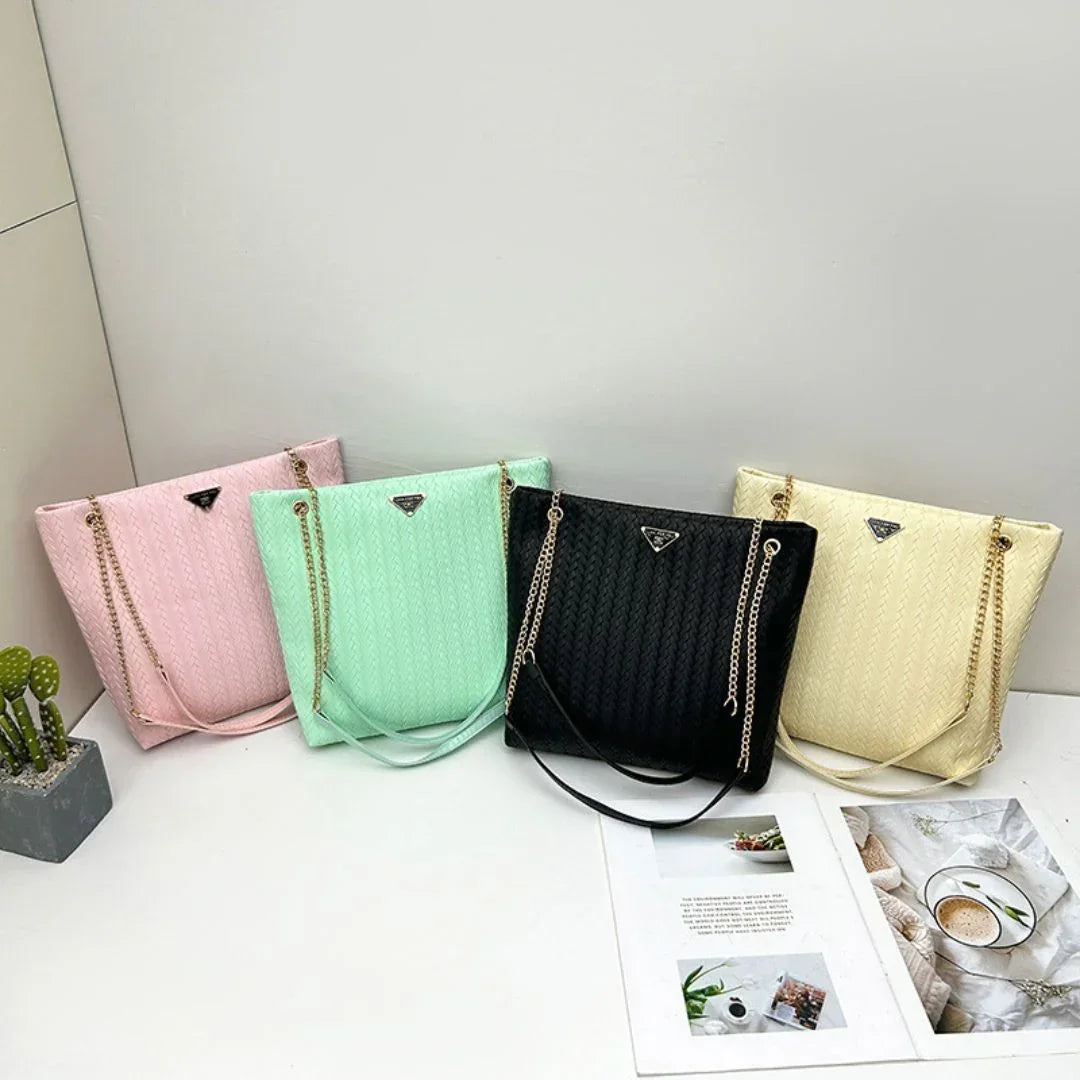 Four quilted tote handbags in pink, mint green, black, and cream with gold chain straps