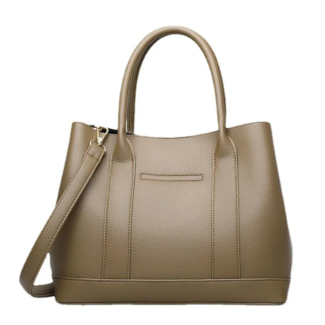 Taupe leather tote bag with two handles and detachable shoulder strap on white background