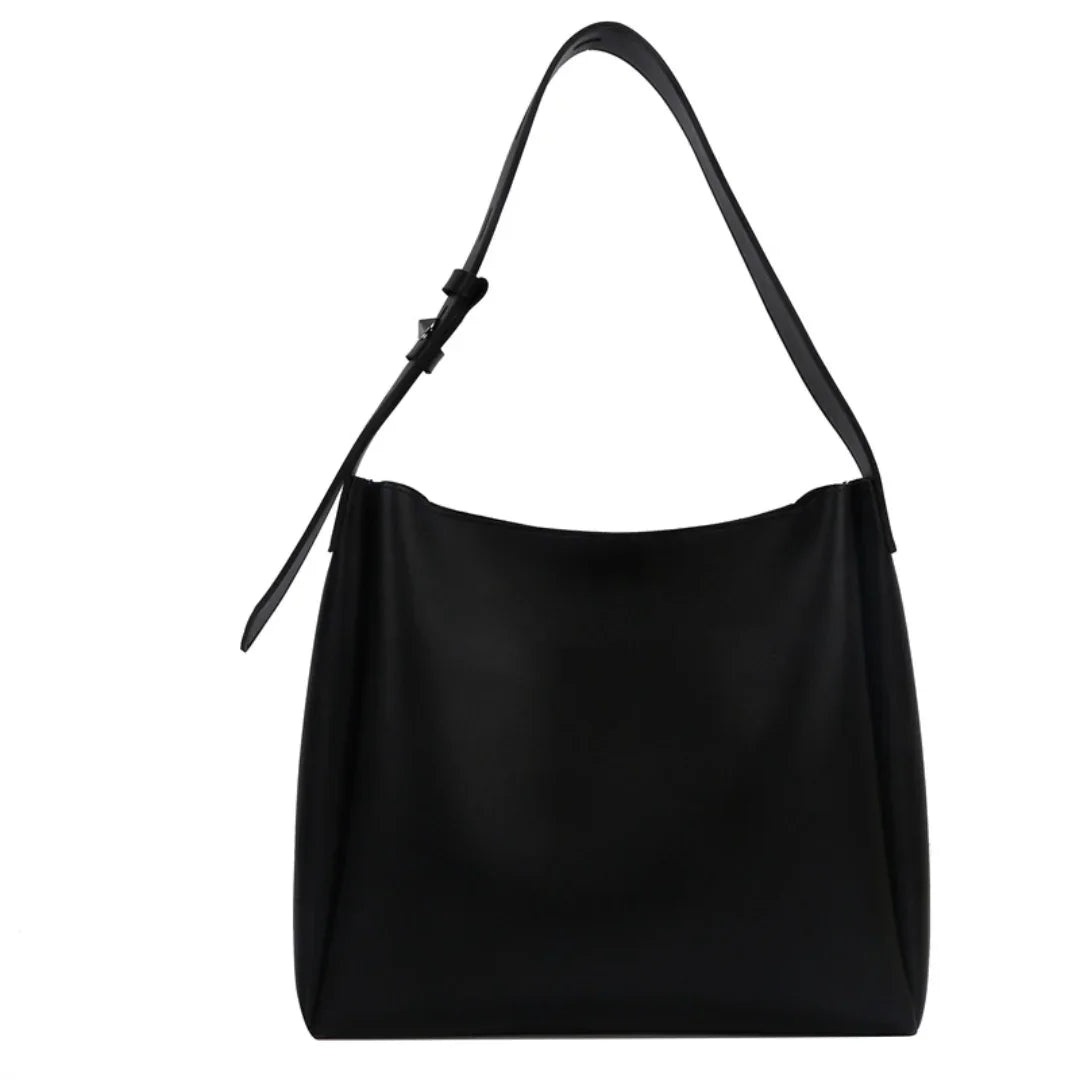 Minimalist black leather shoulder bag with adjustable strap on white background