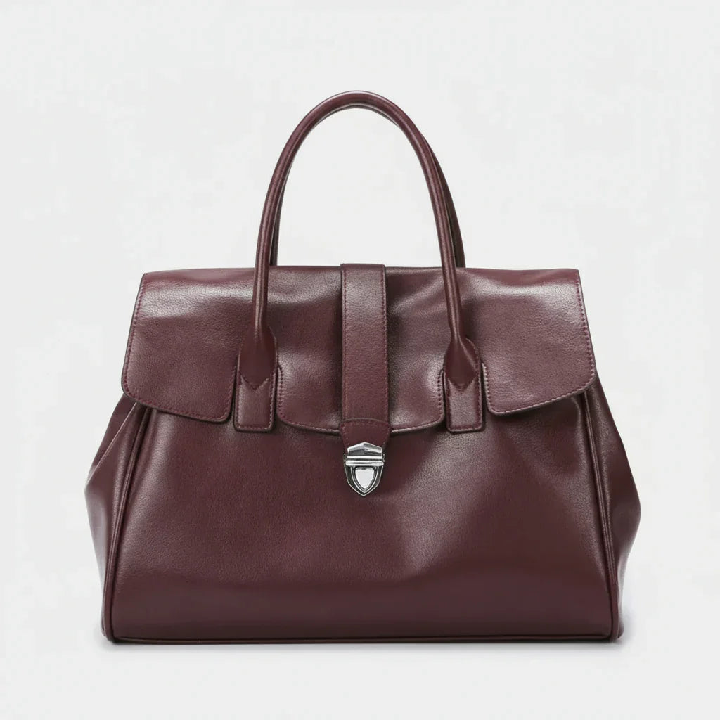 Burgundy leather handbag with top handles and silver clasp on white background