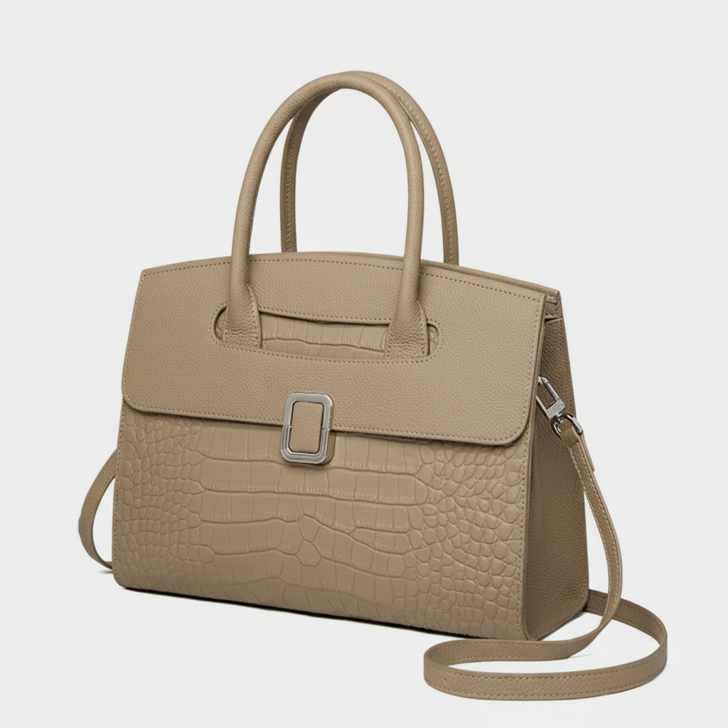 Taupe crocodile-embossed leather handbag with top handles and silver buckle on white background
