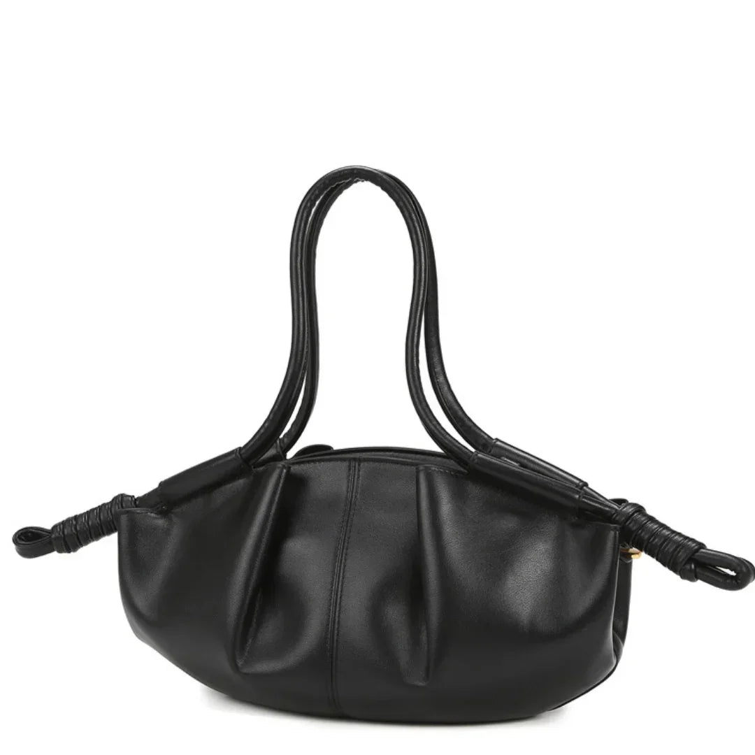 Black leather handbag with double handles and knotted ends against white background