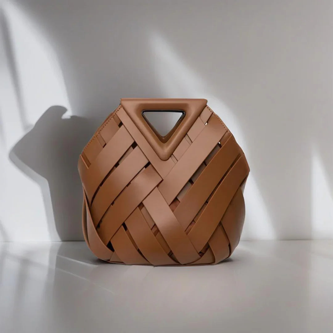 Brown woven leather handbag with triangle handle on white minimalist background