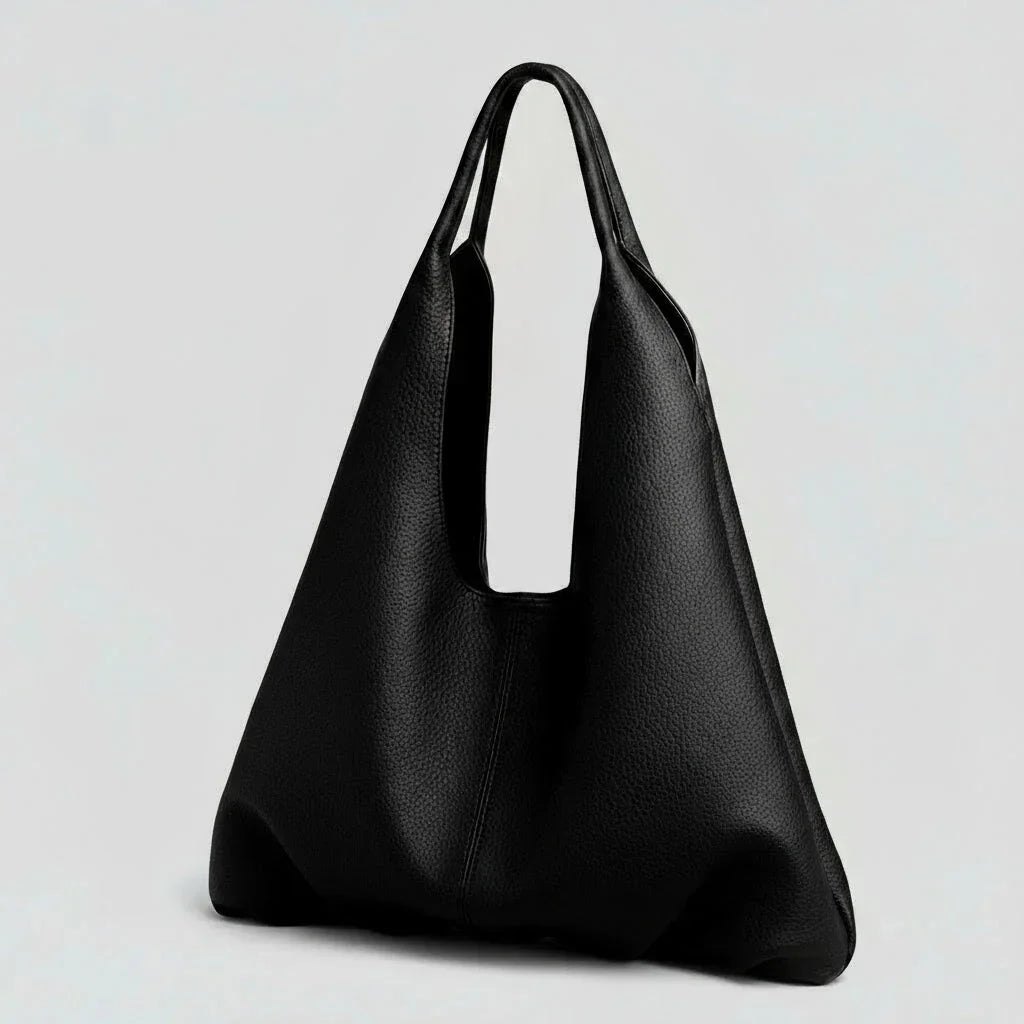 Minimalist black leather tote bag with wide handles on a plain light background