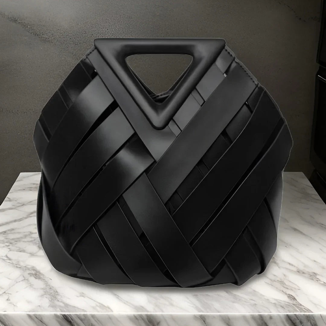 Black woven leather handbag with triangle handle on marble surface