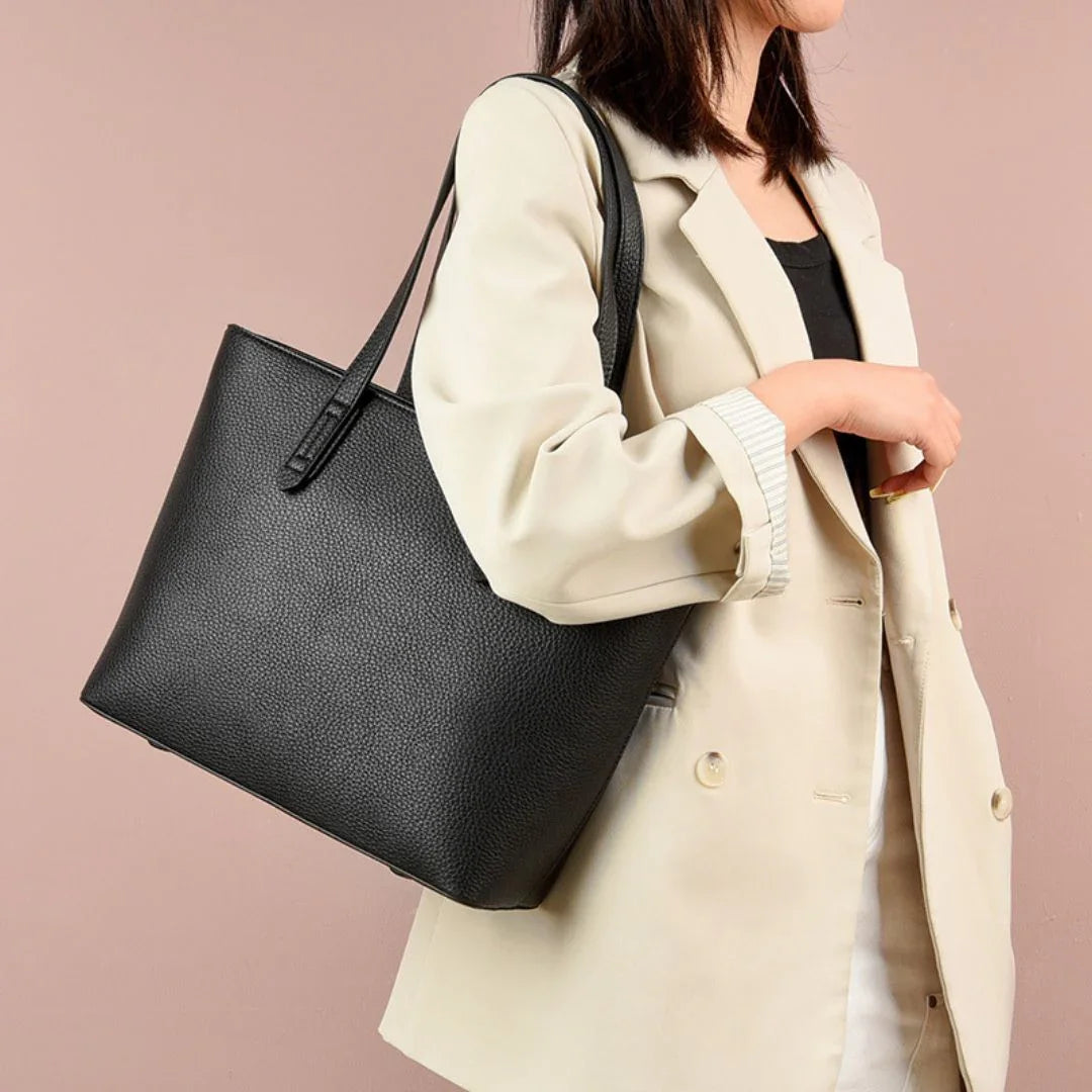 Woman wearing beige blazer carrying black leather tote bag
