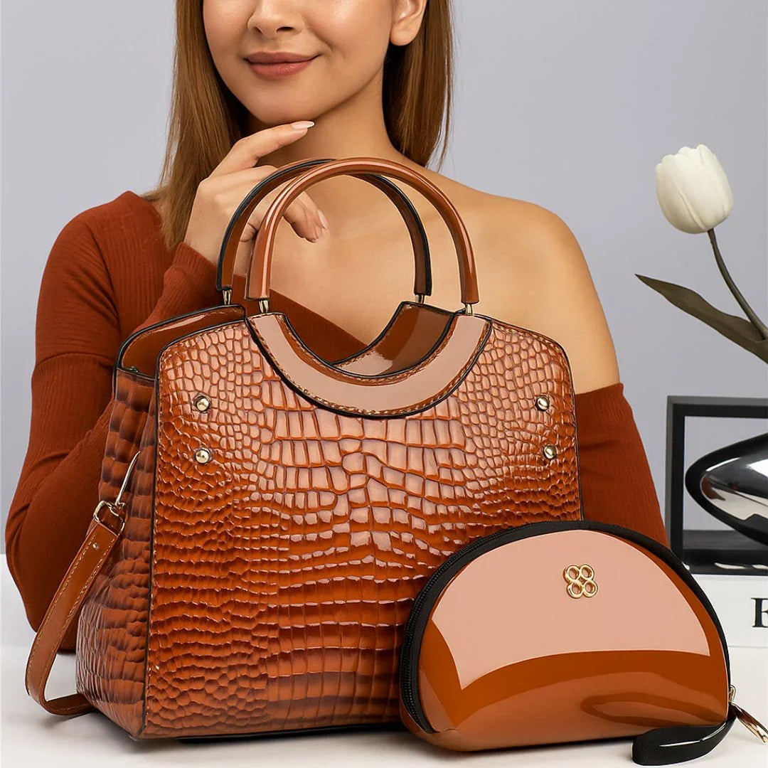 Woman with brown crocodile texture handbag and matching glossy purse on table