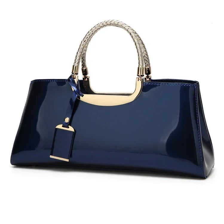 Glossy navy blue handbag with gold accents and braided handles on white background
