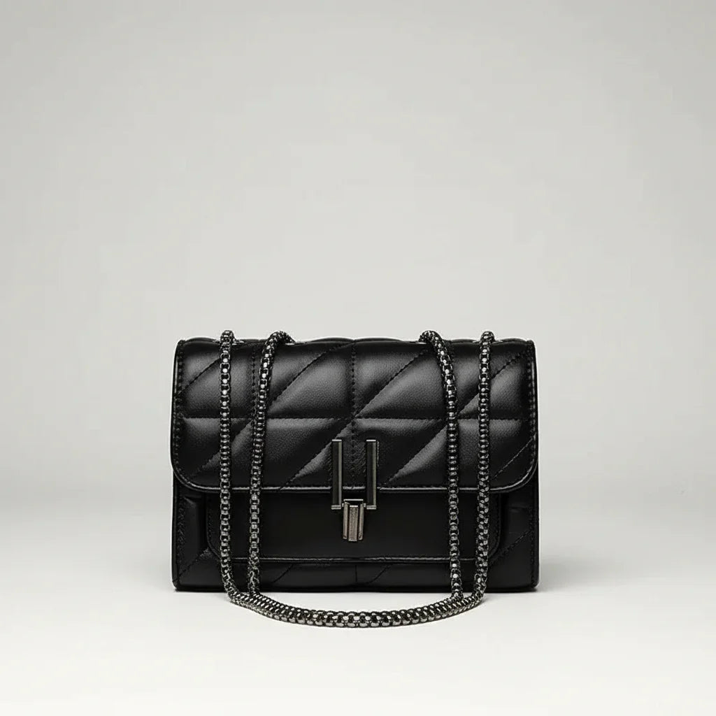 Black quilted leather handbag with chain strap and metal clasp on white background
