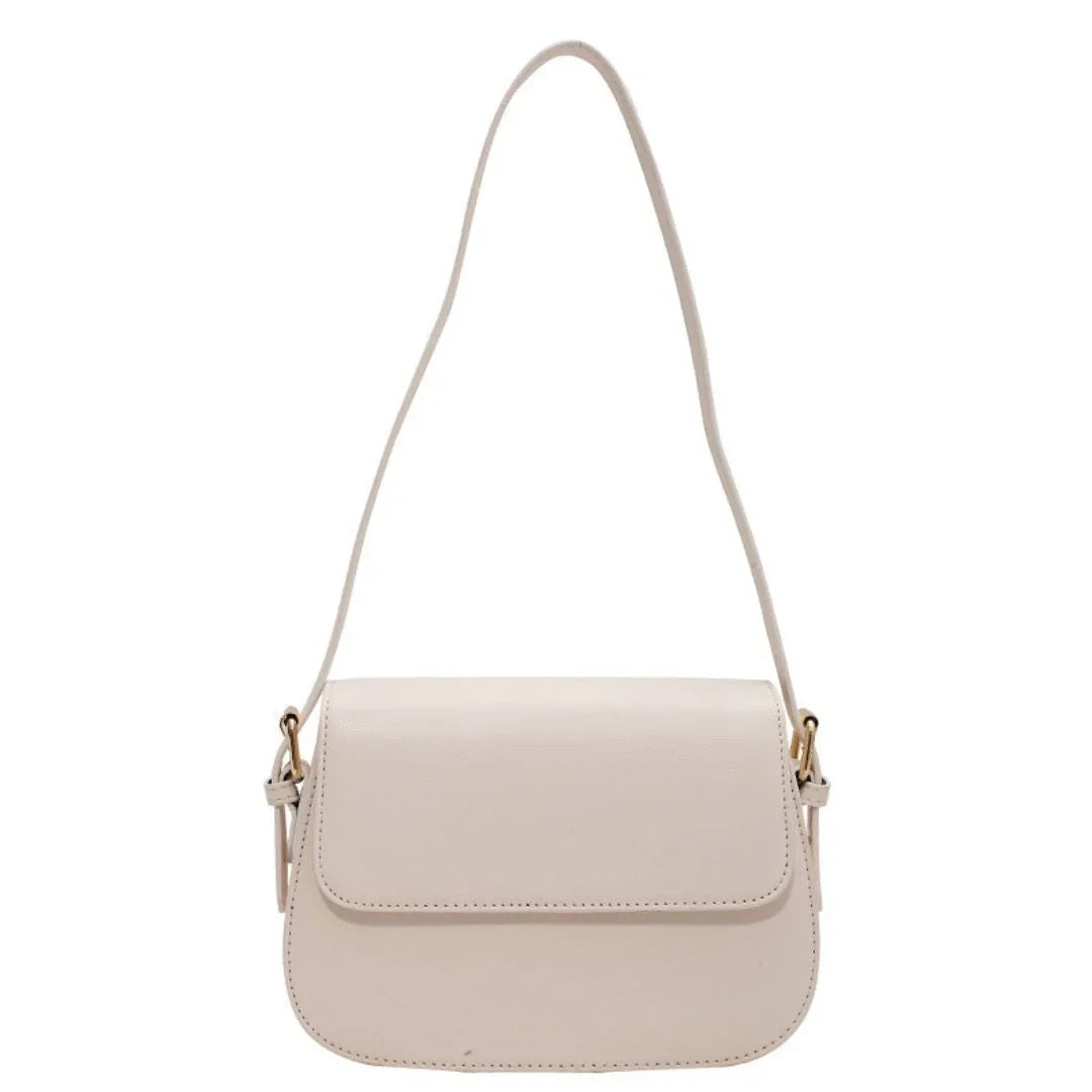Beige leather shoulder bag with flap closure and gold-tone hardware on a white background