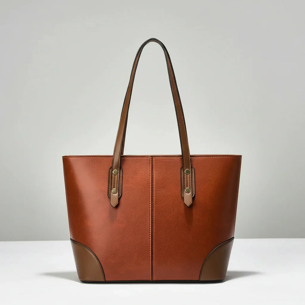 Brown leather tote bag with double handles on a plain white background