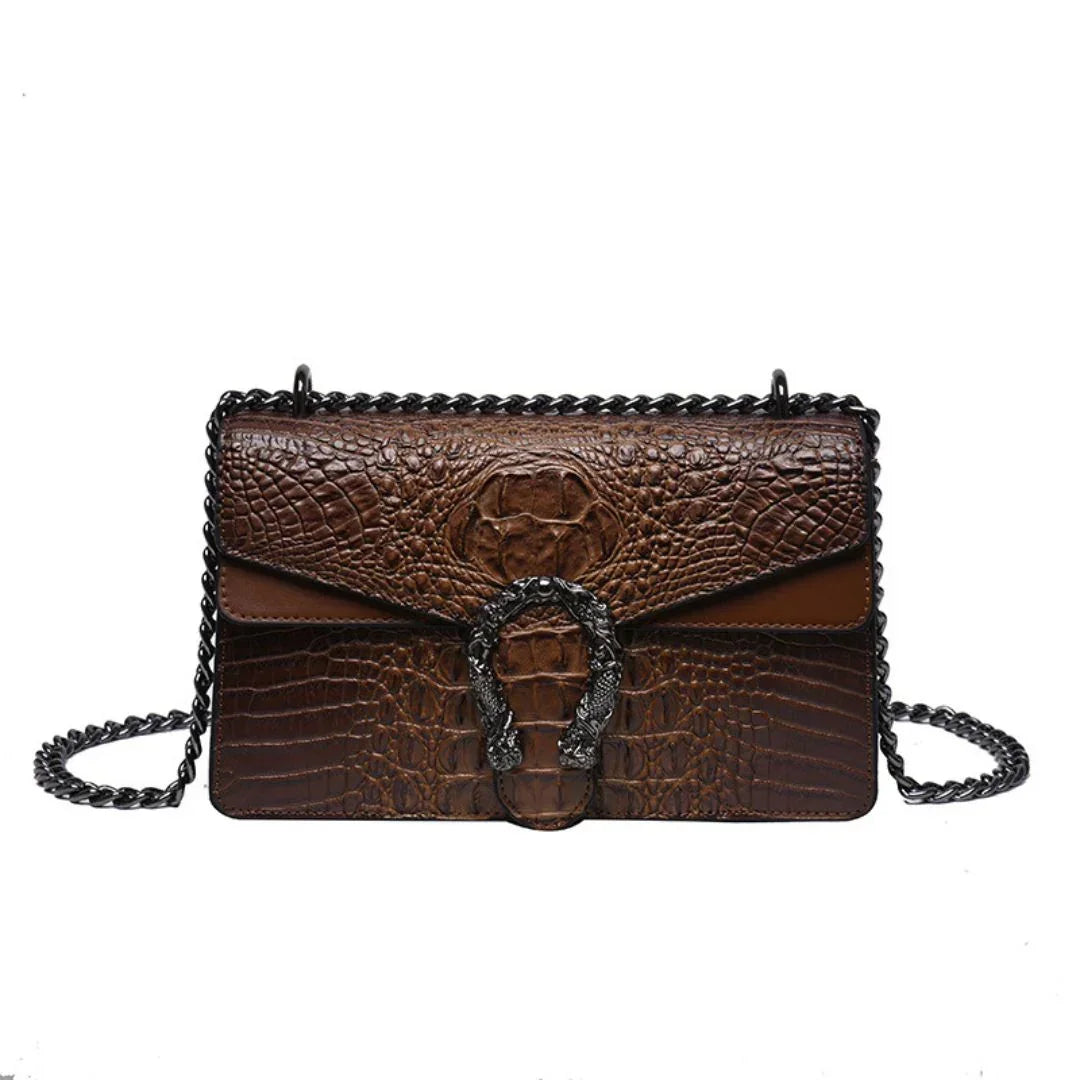 Brown crocodile-embossed leather shoulder bag with black chain strap and ornate metal buckle