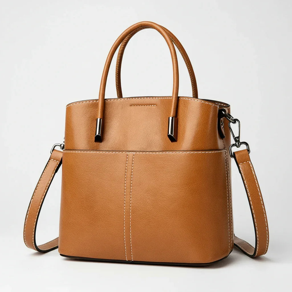 Brown leather handbag with top handles and detachable shoulder strap on white background