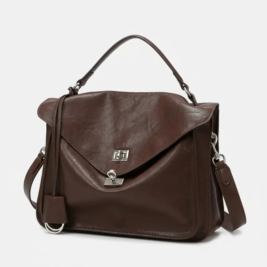 Brown leather satchel handbag with top handle, silver clasp, and detachable strap on white background