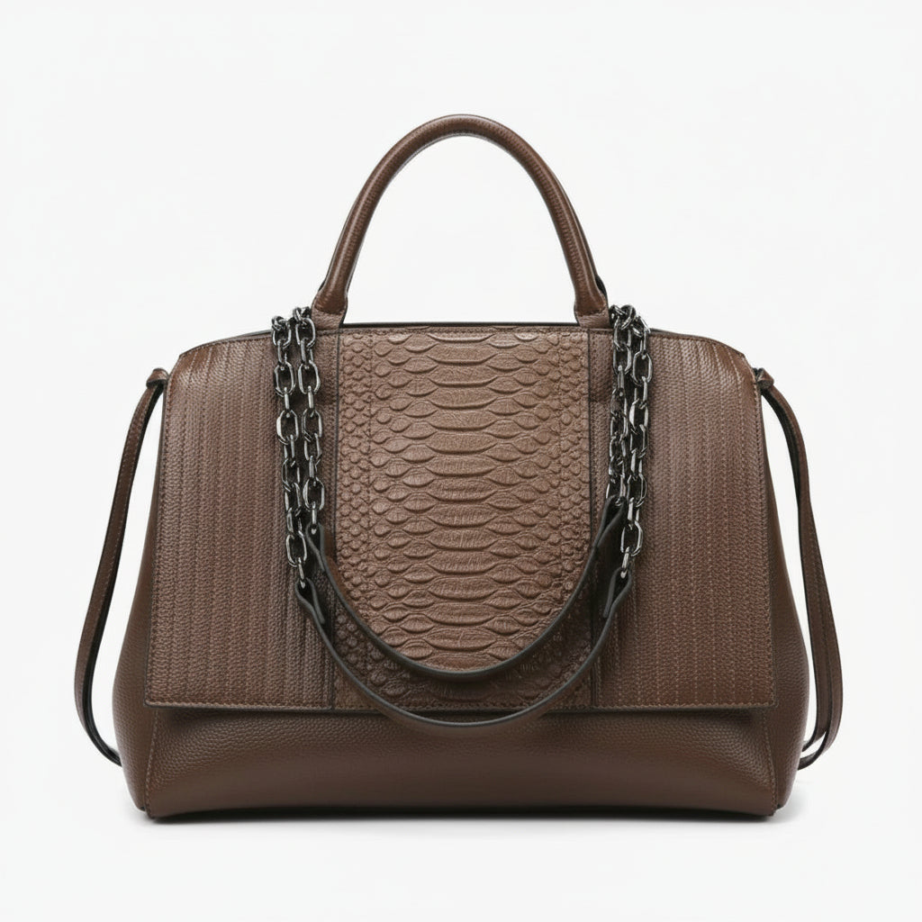 Brown leather handbag with snakeskin pattern, metal chain straps, and top handle on white background