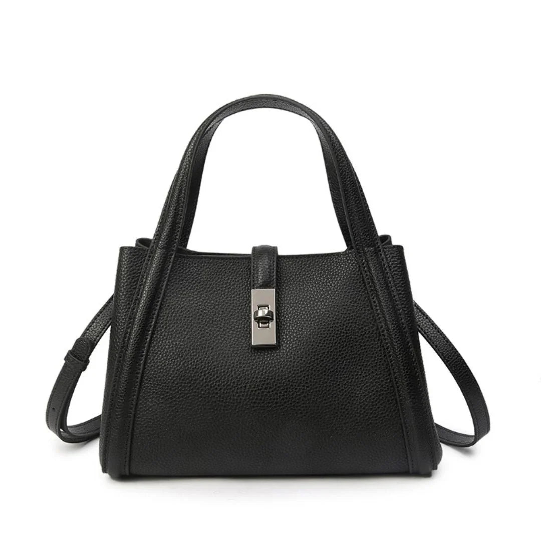 Elegant black leather handbag with top handles, silver clasp, and adjustable strap on white background
