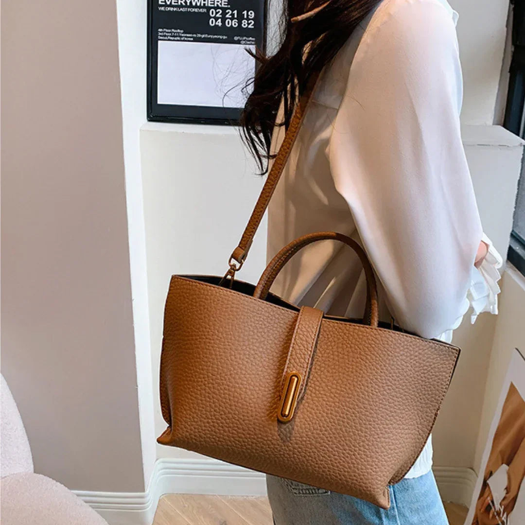 Woman wearing white blouse and jeans with brown leather tote bag crossbody