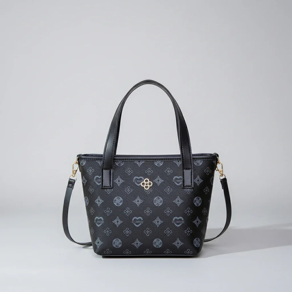 Black leather tote bag with monogram pattern, gold hardware, and detachable shoulder strap