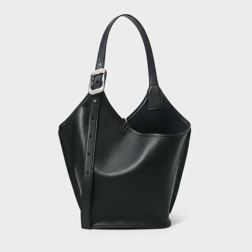 Black leather bucket bag with adjustable strap and silver buckle on white background