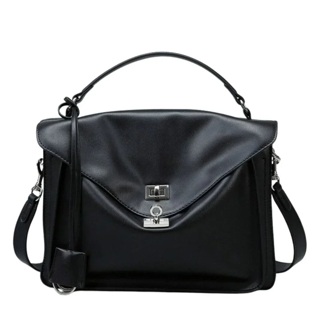 Black leather satchel handbag with top handle and silver clasp on white background