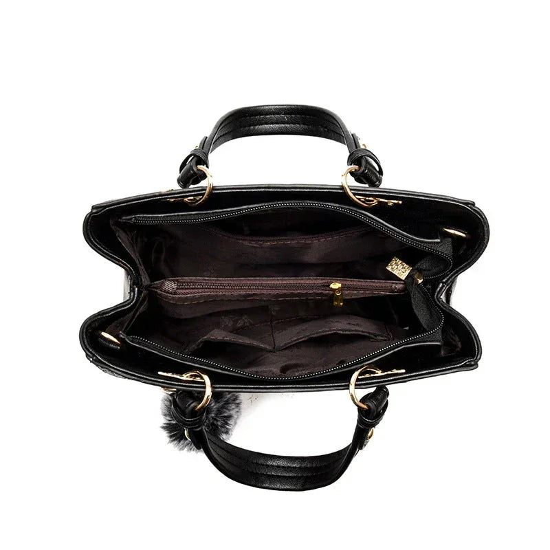 Black leather handbag interior with multiple compartments and gold hardware