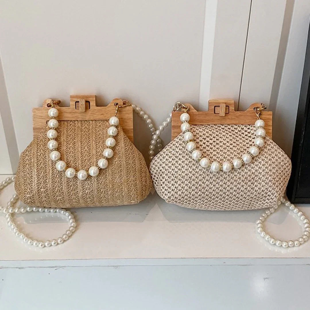 Two woven handbags with wooden frames and pearl bead handles displayed on a white shelf.