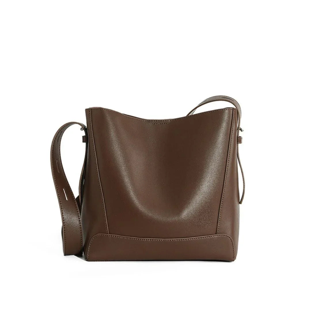 Brown leather shoulder bag with wide strap on white background