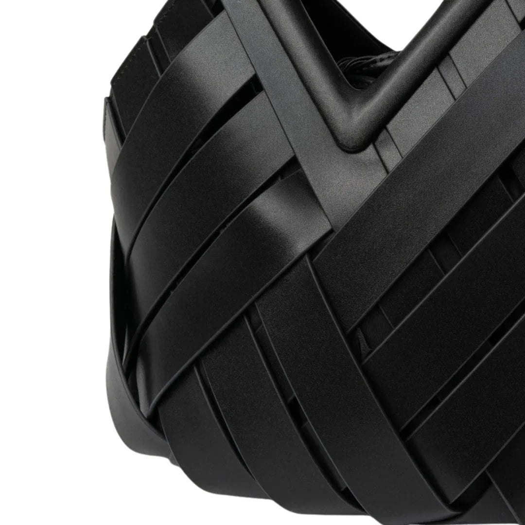 Close-up of modern black woven leather handbag with geometric design