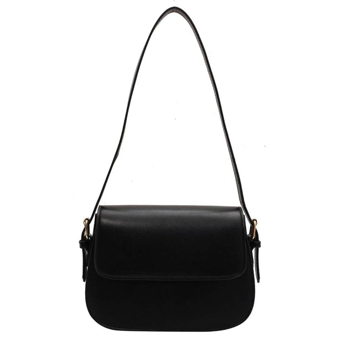 Black leather shoulder bag with flap closure and adjustable strap on white background