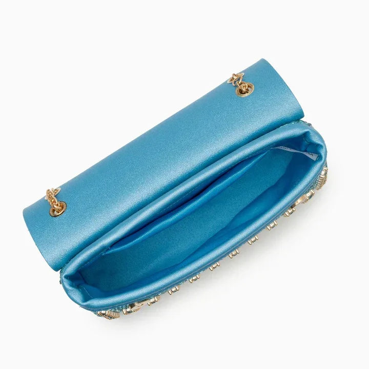 Open blue satin clutch purse with gold chain and rhinestone trim on white background