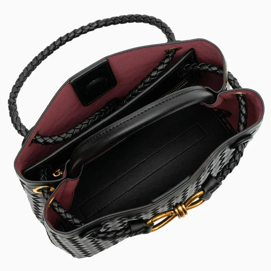 Open black woven leather handbag with braided handle and gold hardware, red interior lining