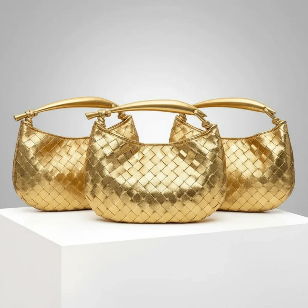 Three gold woven handbags with top handles displayed on a white pedestal
