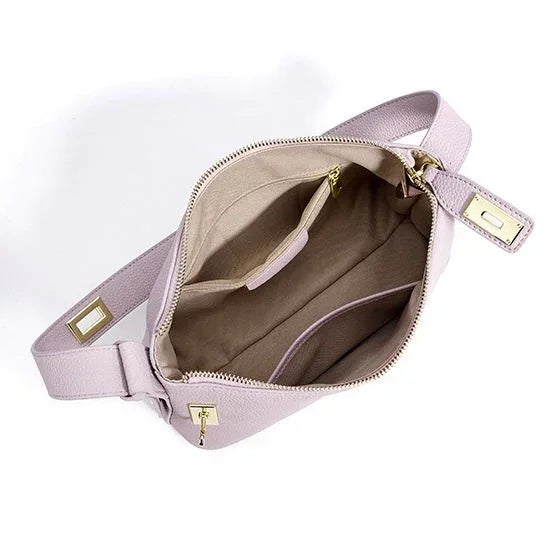 Open light lavender crossbody bag with beige interior and gold zipper accents on white background