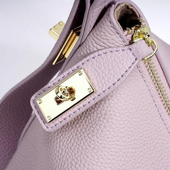 Close-up of light purple leather handbag with gold zipper and hardware