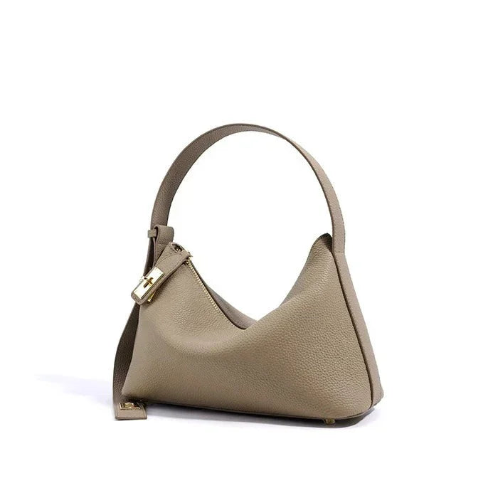 Taupe leather shoulder bag with gold hardware and textured finish on white background