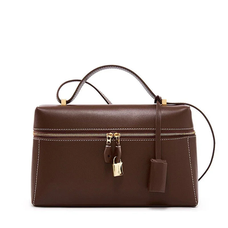 Brown leather handbag with gold zipper and lock, white stitching, and top handle