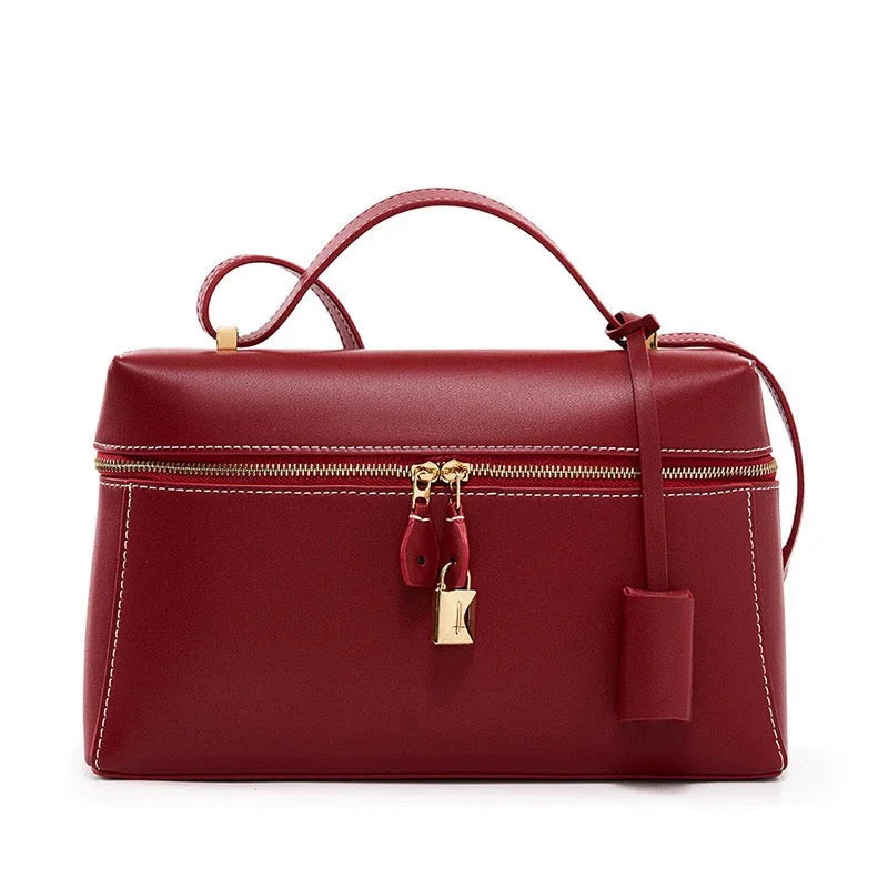 Red leather handbag with gold zipper and padlock, top handle, and white stitching