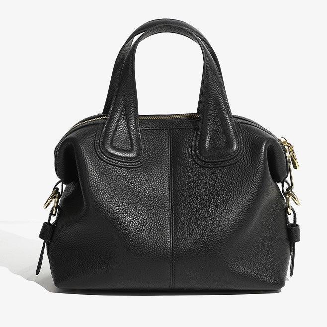 Black leather handbag with top handles and gold zipper on a white background