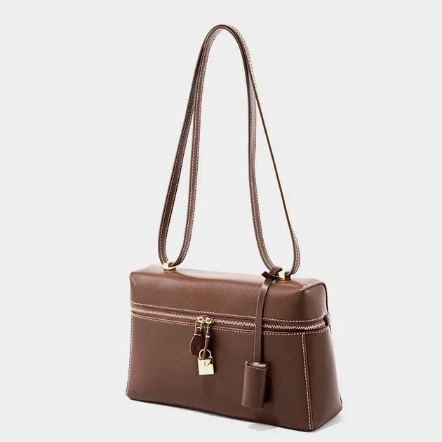Brown leather shoulder bag with gold zipper, lock charm, and double strap on white background