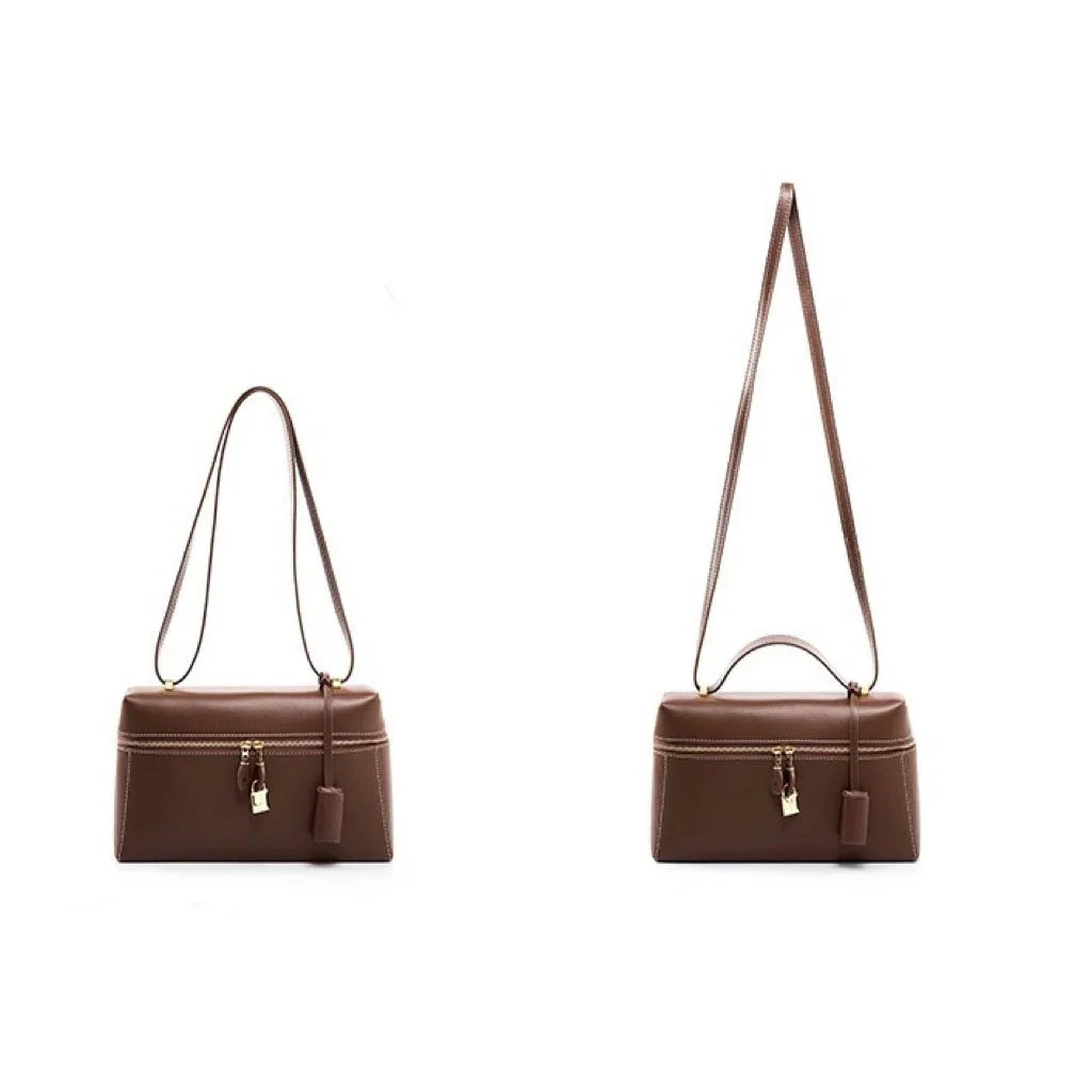 Brown leather handbag with gold clasp and adjustable strap on white background