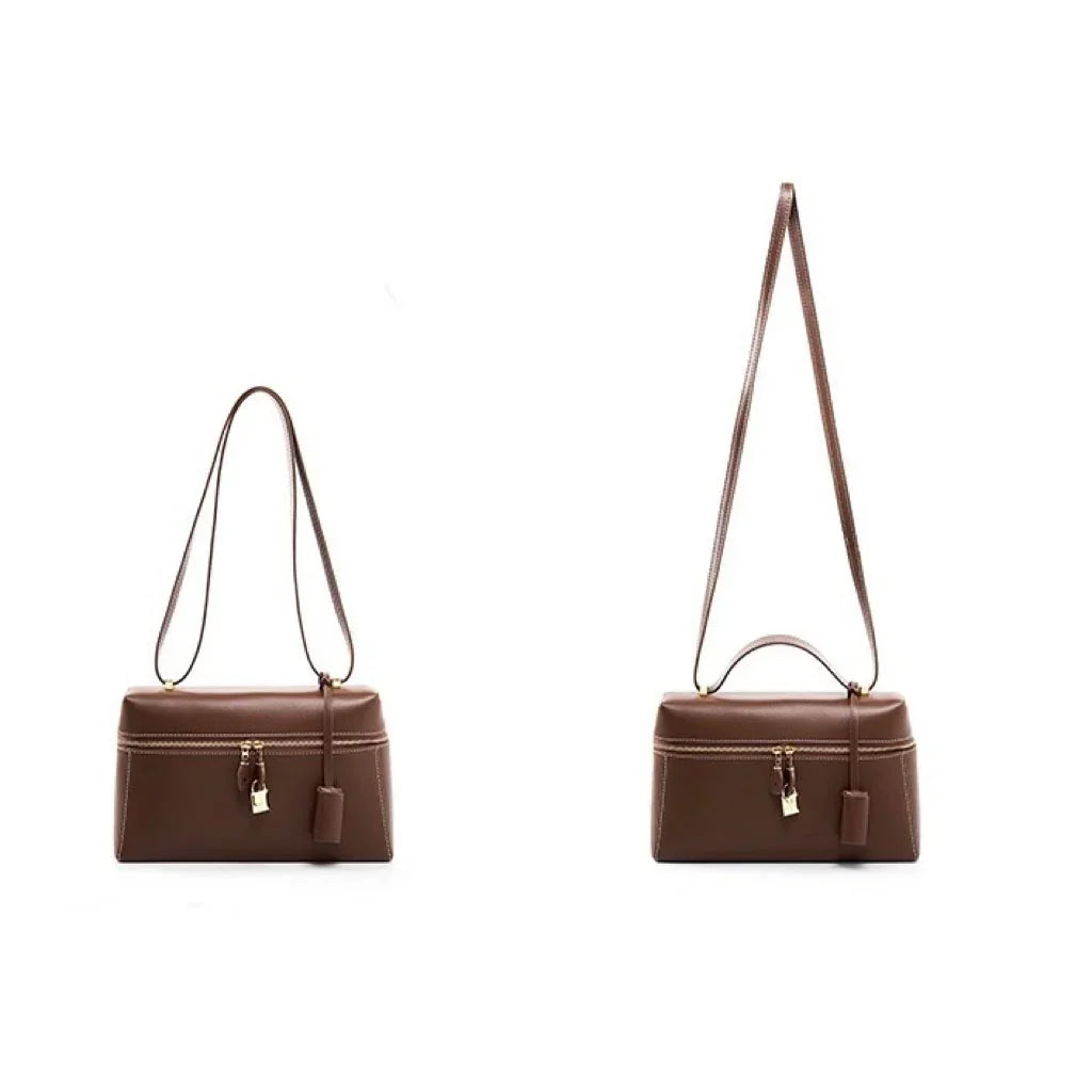 Brown leather handbag with gold clasp and adjustable strap on white background