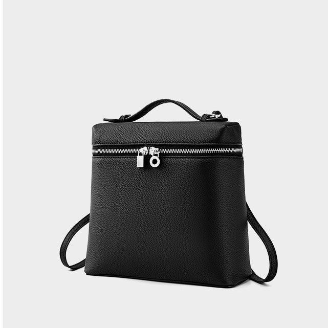 Black leather backpack with top handle and silver zipper on plain background