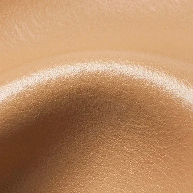 Close-up of smooth beige leather texture with curved contour for upholstery or accessories