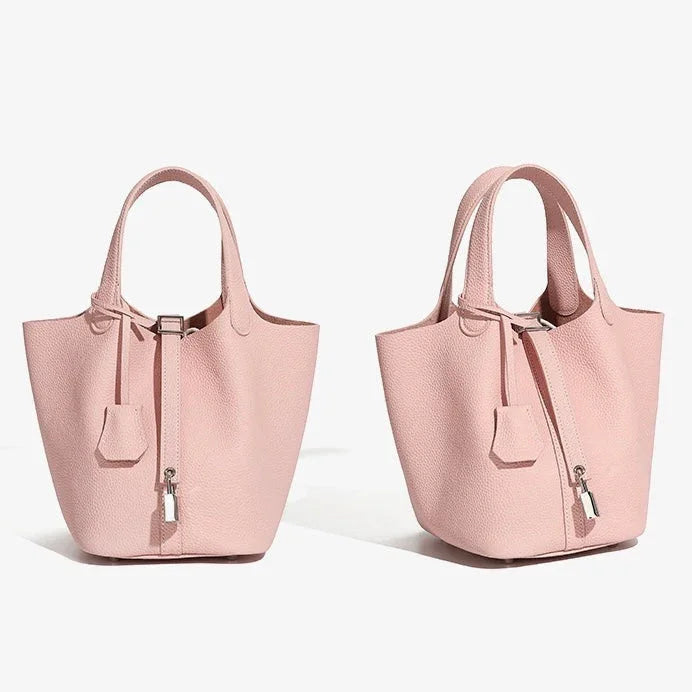 Two light pink leather bucket handbags with top handles and silver lock detail