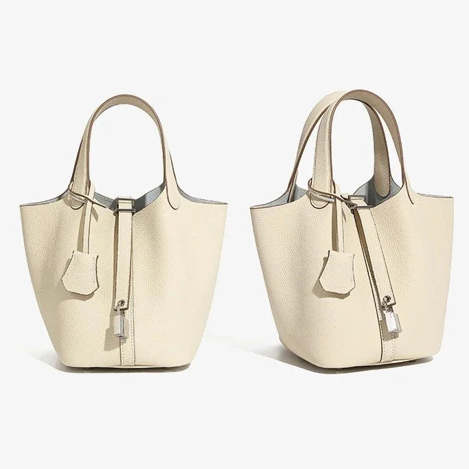Two beige leather tote handbags with top handles and silver hardware on a white background