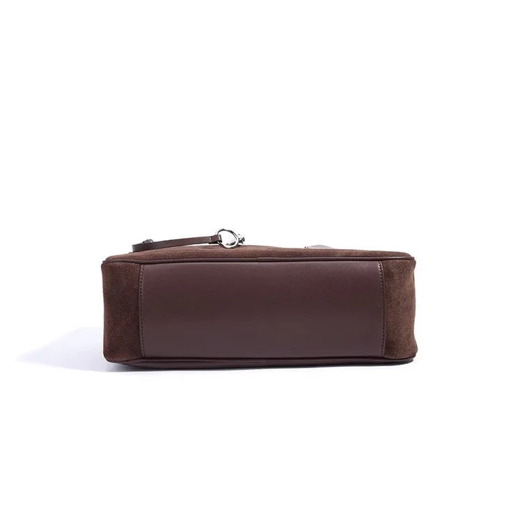 Bottom view of brown suede and leather rectangular bag on white background
