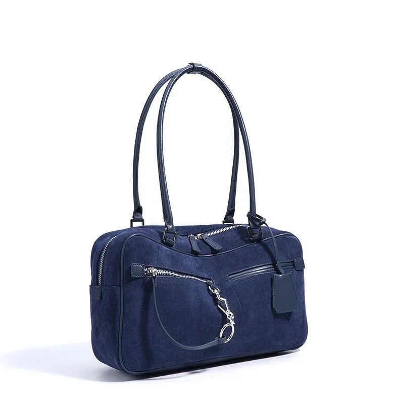 Navy blue suede handbag with double handles and zippered front pocket on white background