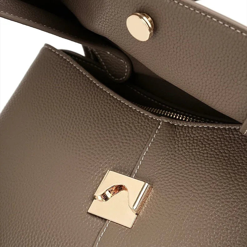 Taupe leather handbag close-up with gold hardware and textured stitching detail