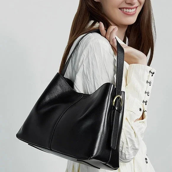 Woman in white blouse carrying a black leather shoulder bag fashion accessory